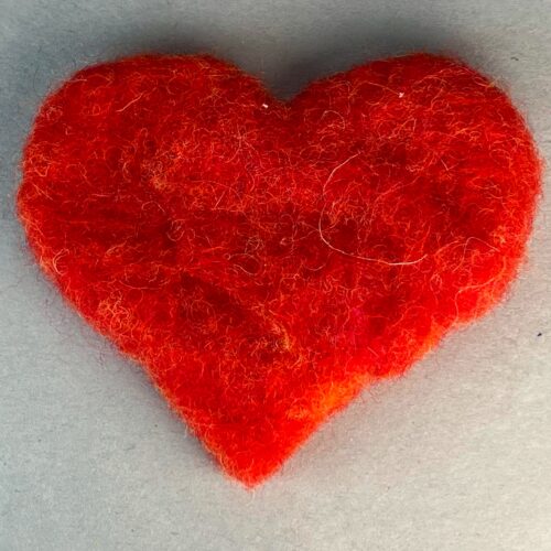 Needle Felted Hearts Kit. Red wool heart against a grey background.
