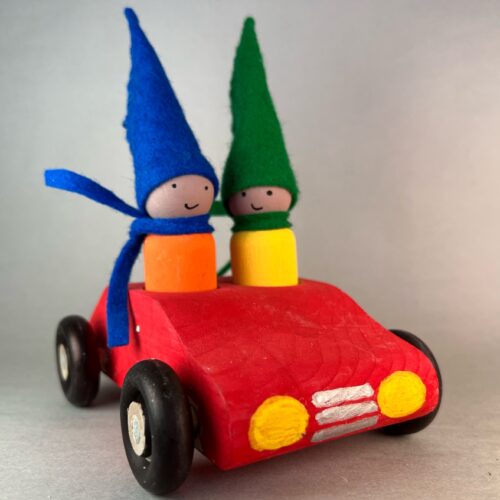 Gnome Mobile Kit. Two peg gnomes with tall cone hats and felt scarves ride in the completed gnome mobile.