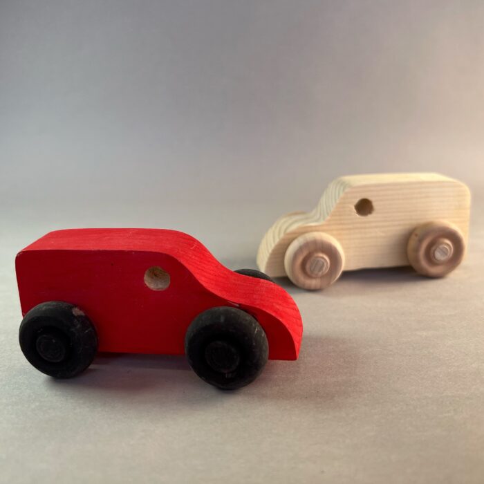 Painted Vehicles Kit. Two indentical vehicles: one is unpainted pine, the other is painted red with black tires.