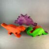 Watercolor Dinosaurs Kit. Three dinosaurs stand in a group: a purple Stegasaurus, an orange T-Rex, and a green brontosaurus.