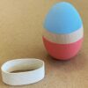 Egg Decorating Kit. One wooden egg, painted light blue on the top and coral on the bottom, with an unpainted stripe between the two colors.