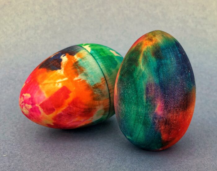 Egg Decorating Kit. Two vibrant wooden eggs that have been decorated using color bleed tissue paper.